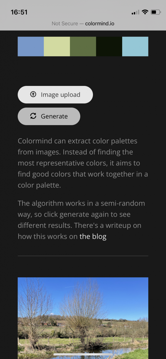 Screenshot from a mobile phone of a page called 'colormind.io'. At the bottom of the page is a photo of a river, field and sky. At the top are five rectangles of colour (two blues, two greens and a black) arranged in a line. Two buttons read 'image upload' and 'generate'. The main body of text says 'Colormind can extract colour palettes from images. Instead of finding the most representative colors, it aims to find good colors that work together in a color palette. The algorithm works in a semi-random way, so click generate again to see different results. There's a writeup on how this works on the blog.'.